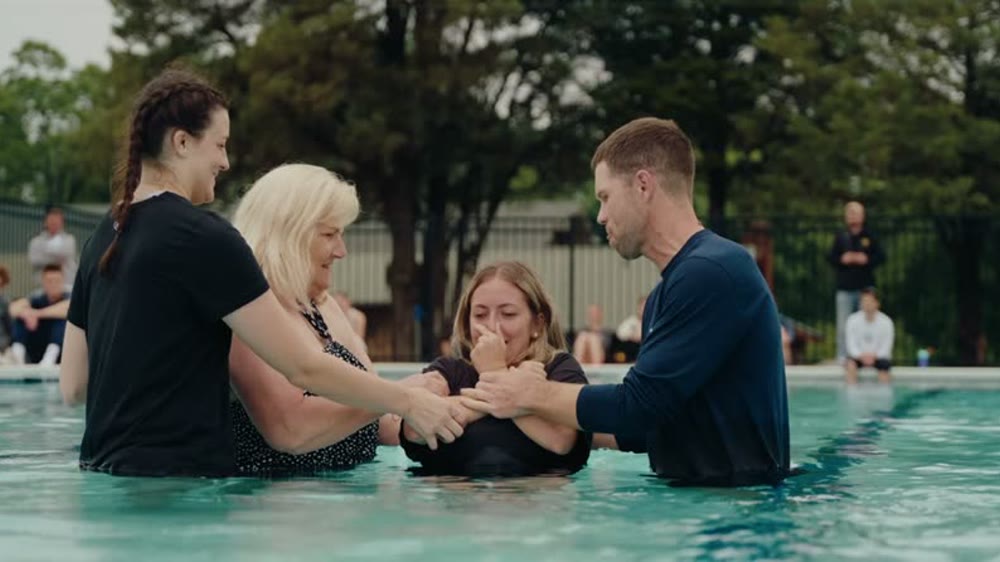 Campers and leaders embracing during a baptism at MACC 2026