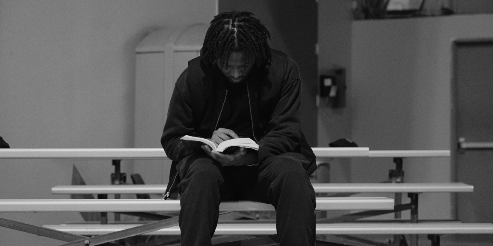 A student reading on the bleachers