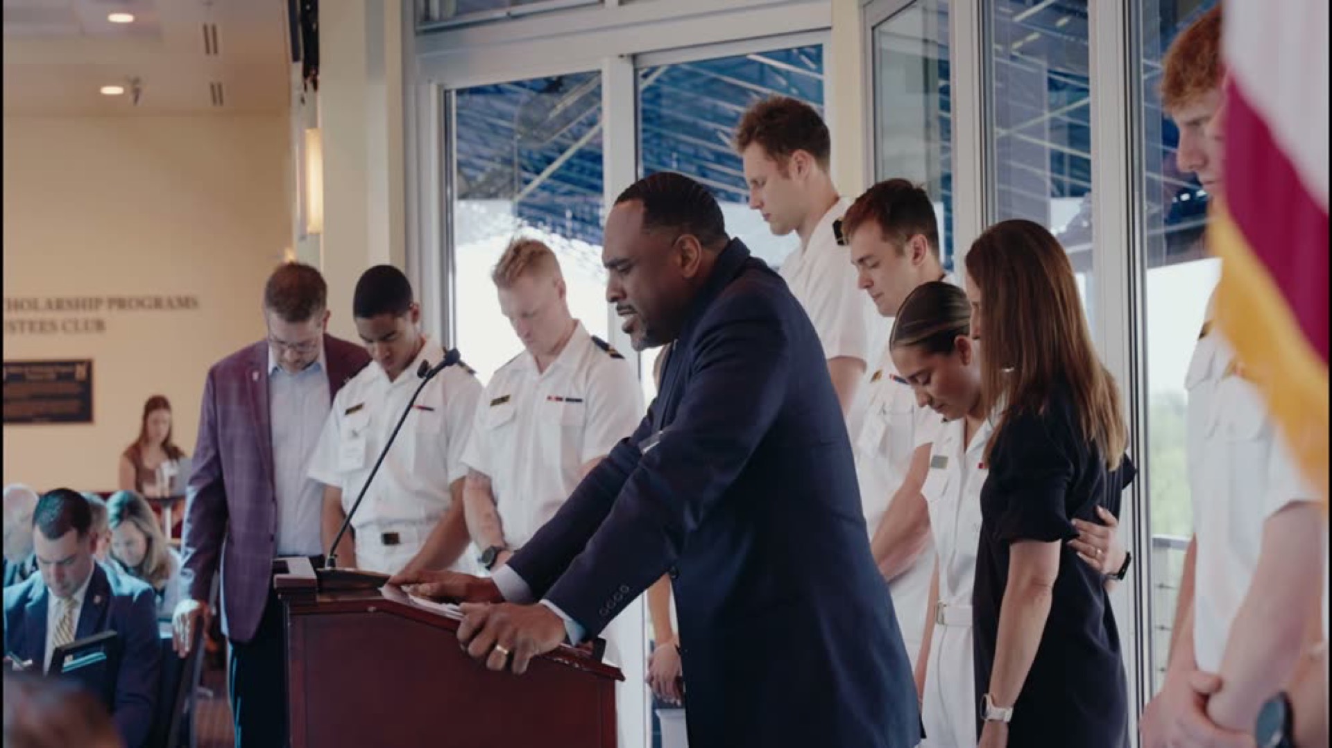 A speaker with midshipmen at the Navy FCA banquet